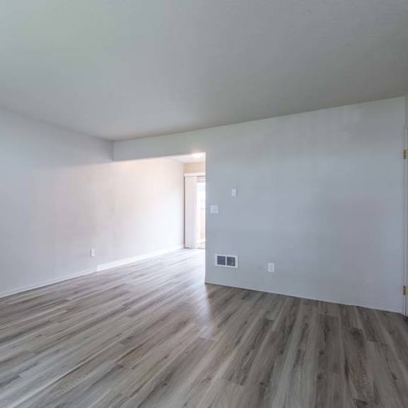 an empty room with white walls and a wooden floor