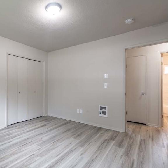 a bedroom with white walls and a wooden floor