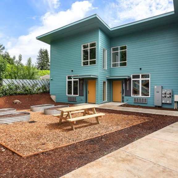 a blue house with a picnic table in front of it