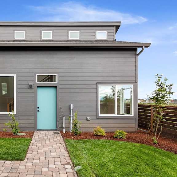 a gray house with a blue door