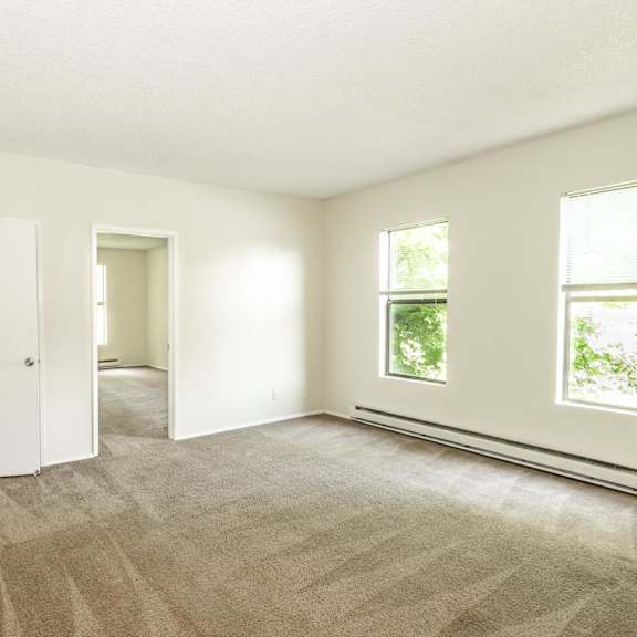 a room with carpeted floor and two doors.