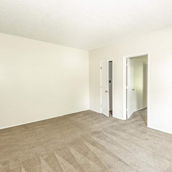 a room with carpeted floor and two doors.