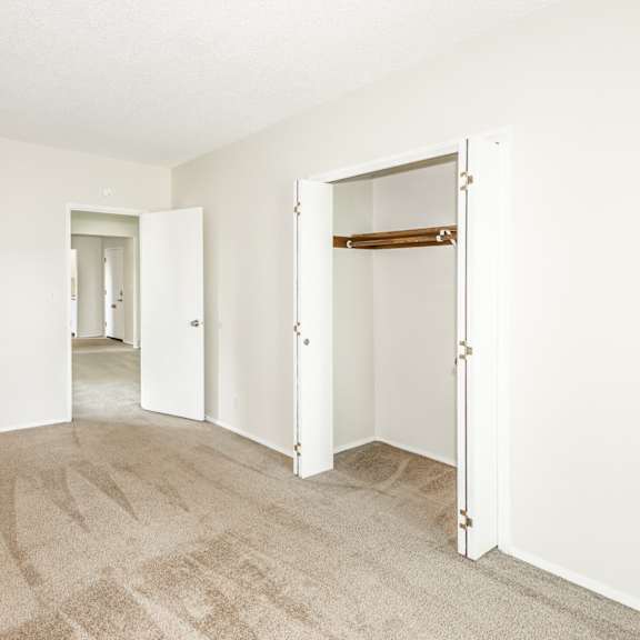 a room with a carpeted floor and two open doors.