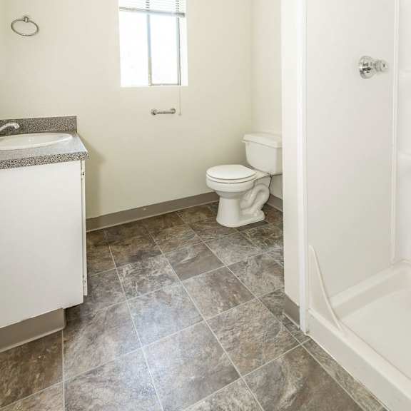 a bathroom with a toilet, sink, and tiled floor.