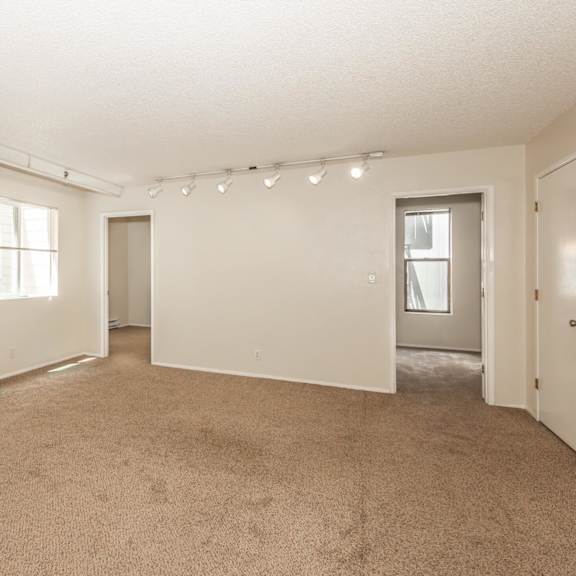 a large empty room with carpeted floor and white walls.