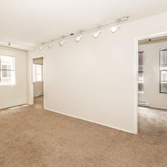 a large, empty room with carpeted floors and white walls.