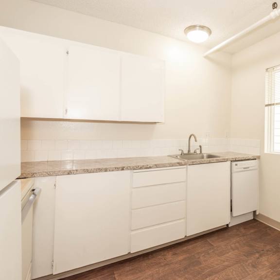 a kitchen with white cabinets and a granite countertop.