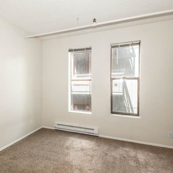 a room with a window and a carpet on the floor.