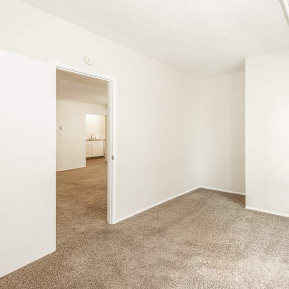 a room with white walls and carpeted floor.