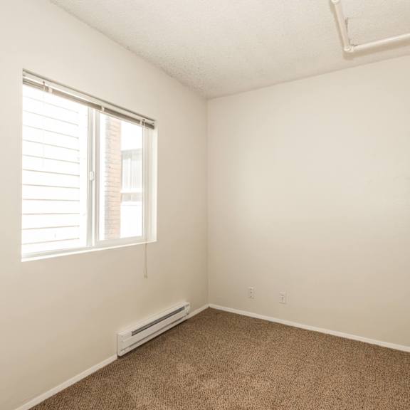 a room with a window and a carpeted floor.
