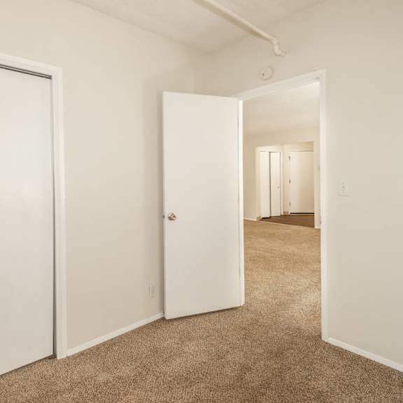 a hallway with two doors on the left and one on the right.