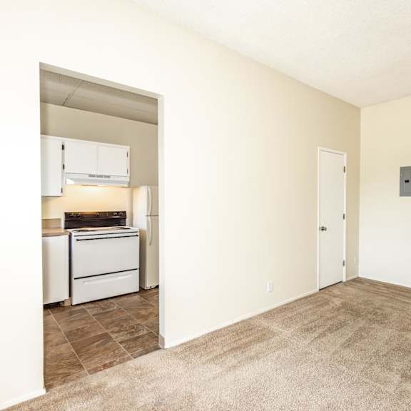 a room with a carpeted floor and a wall-mounted air conditioner unit.