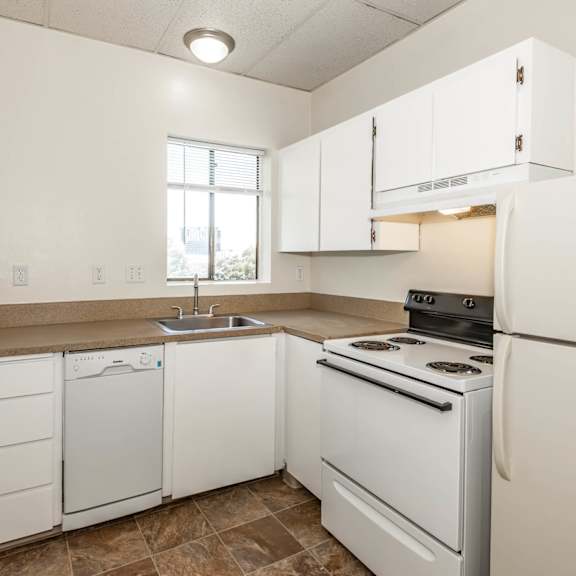 a kitchen with white cabinets and appliances.