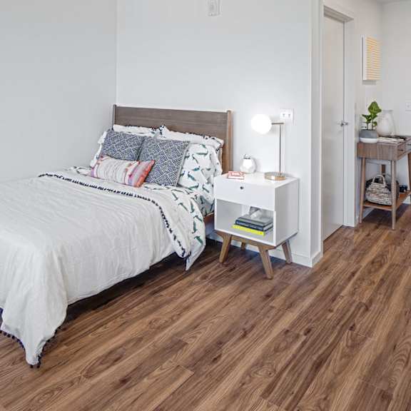 a bedroom with a bed, nightstand, and basket.
