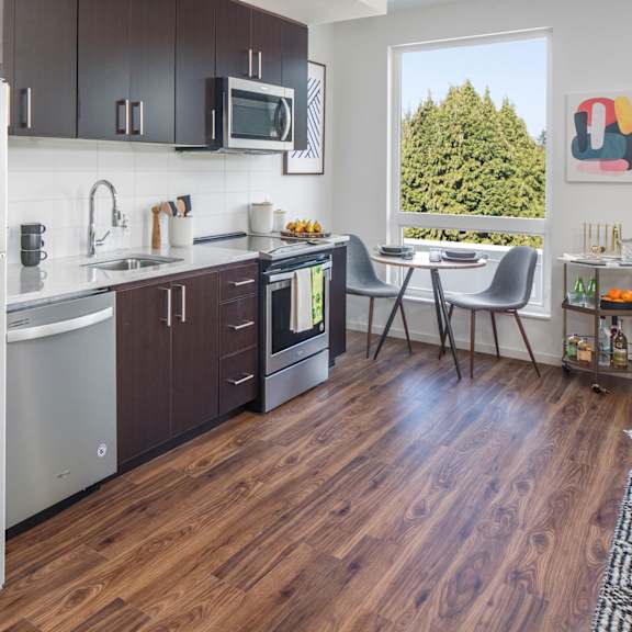 a kitchen with a white refrigerator and wooden floors.
