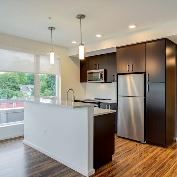 a modern kitchen with dark wood cabinets and a white countertop.