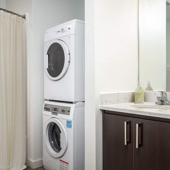 a white front loading washing machine in a bathroom.