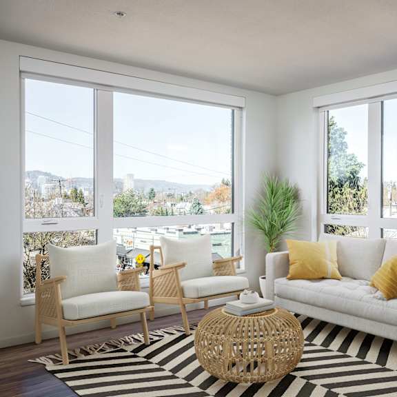 a living room with a white couch, two chairs, and a woven coffee table.