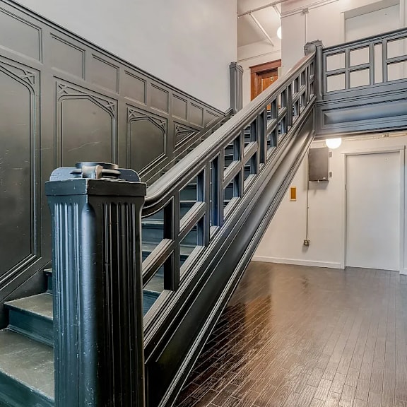 a staircase with a metal railing and wooden steps at clay & tiffany, portland, 97201