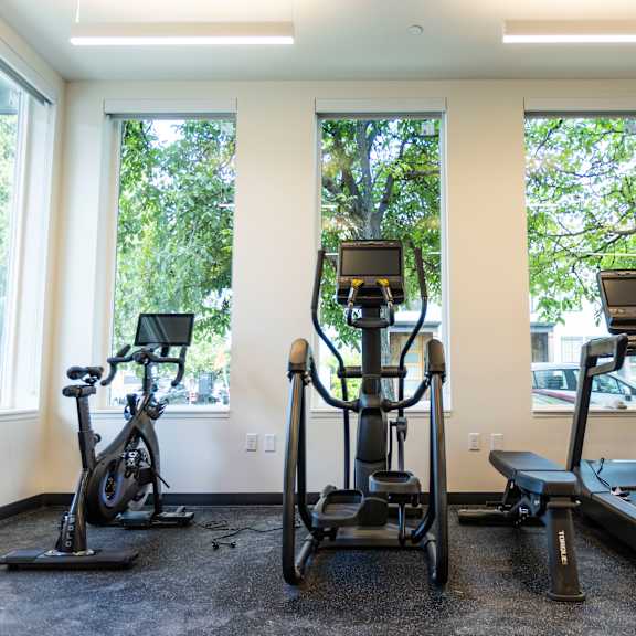 three exercise machines in a gym with three windows at shift, portland oregon