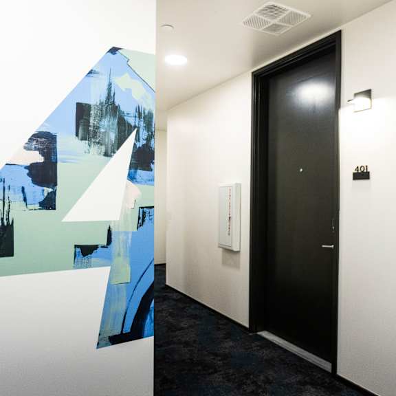 a hallway with a mural on the wall and a black door at shift, portland, or