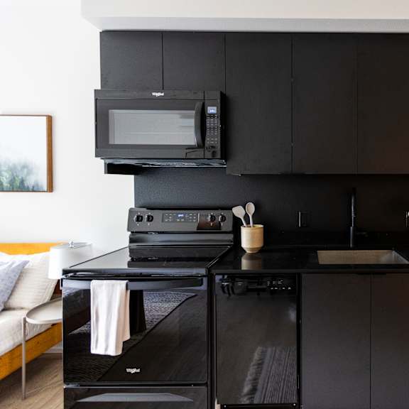 a kitchen with black cabinets and a sink and a microwave at shift, oregon, 97217