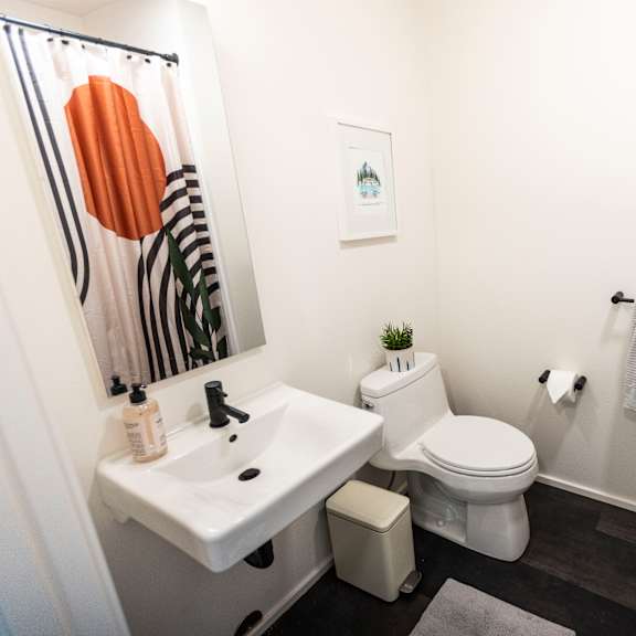 a bathroom with a white toilet and a sink and a shower curtain at shift, portland, or
