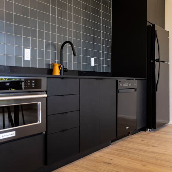 a kitchen with black cabinets and a stainless steel oven and sink at shift, oregon