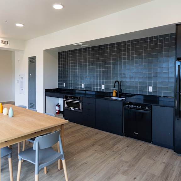 a kitchen and dining room with black appliances and a wooden table at shift, portland
