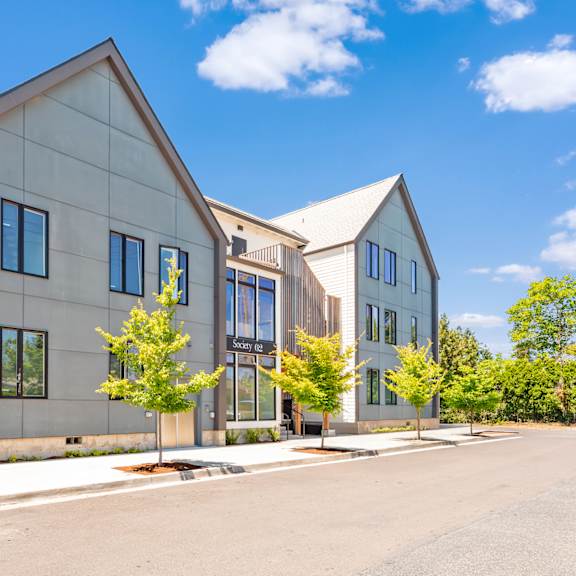 a modern house with a grey exterior and a black gate at society 62 apartments, portland, oregon