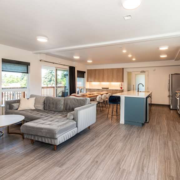 a living room with a grey couch and a round table at society 62 apartments, portland