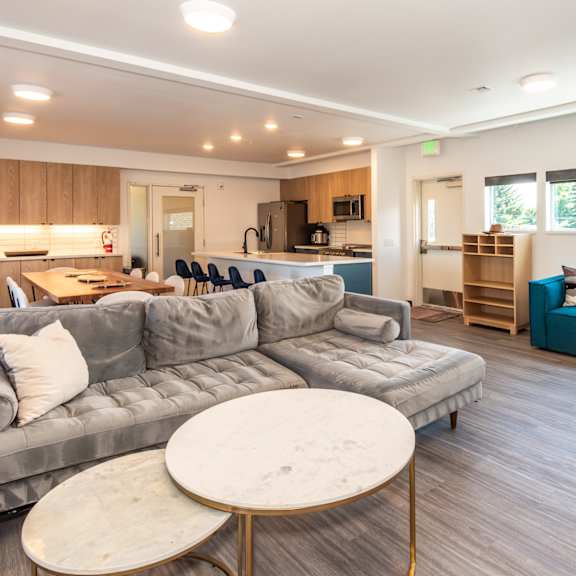 a modern living room with a grey sofa and a round marble table at society 62 apartments, oregon, 97213