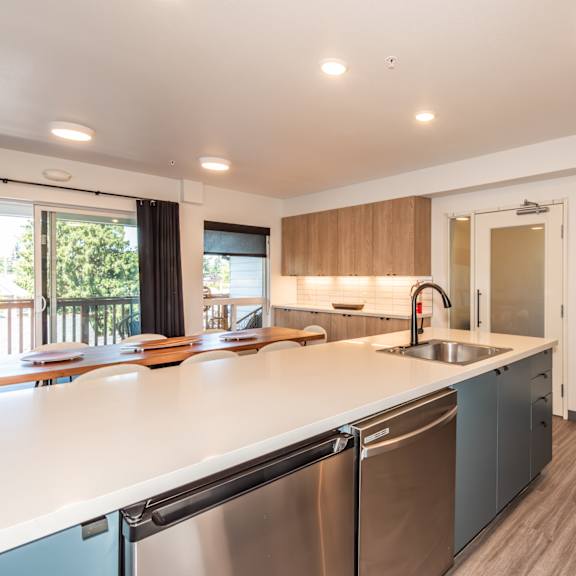 a modern kitchen with stainless steel appliances and wooden cabinets at society 62 apartments, portland, or