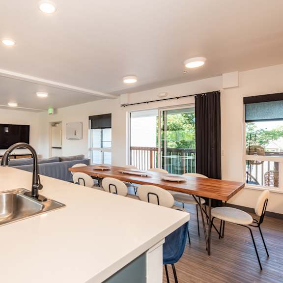 a kitchen with a sink and a dining table with chairs at society 62 apartments, portland, or, 97213