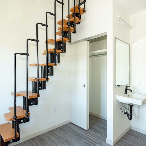 a white bathroom with a black metal staircase at society 62 apartments, portland, oregon
