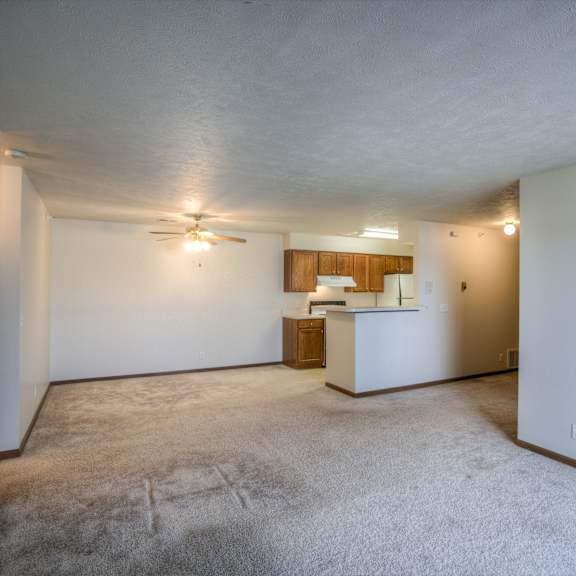 a room with a carpeted floor and a ceiling fan.