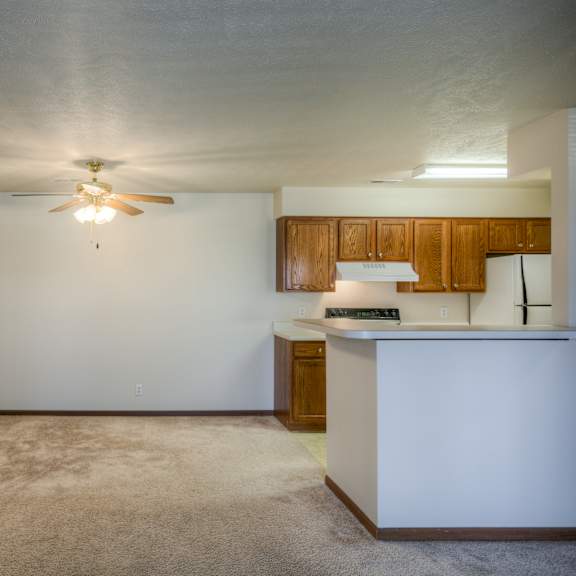 a room with a ceiling fan and a counter.