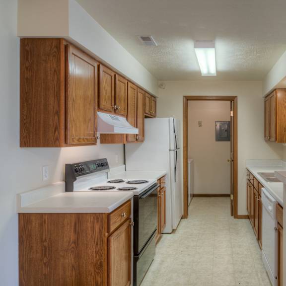 a kitchen with white appliances and wooden cabinets.