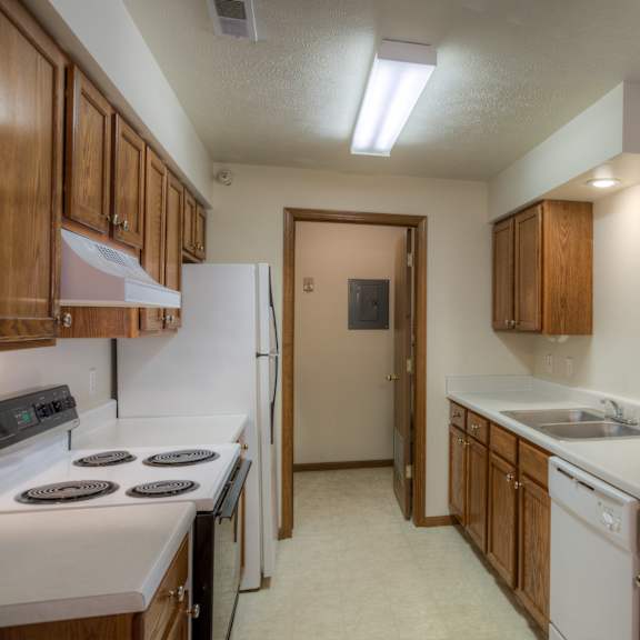 a kitchen with white appliances and wooden cabinets.