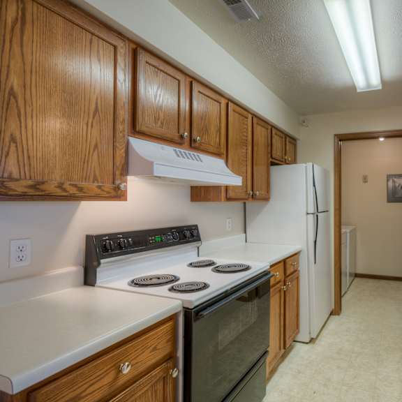 a kitchen with wooden cabinets and a black stove top.