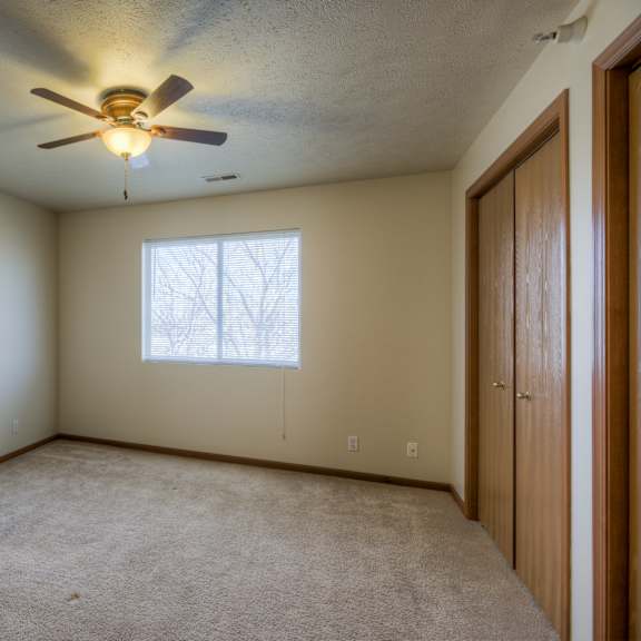 a room with a ceiling fan and a window.
