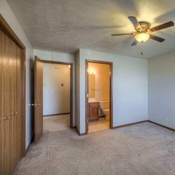 a room with a ceiling fan and carpeted floor.