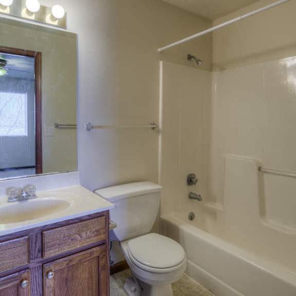 a white toilet sits in a bathroom next to a sink and a bathtub.