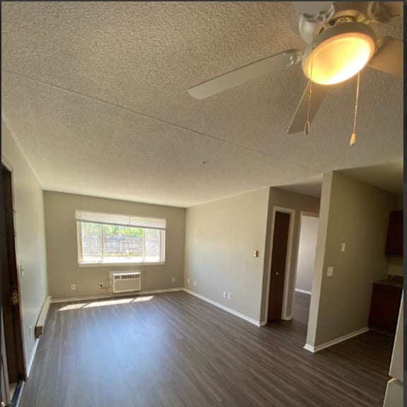 a room with a ceiling fan and a window.