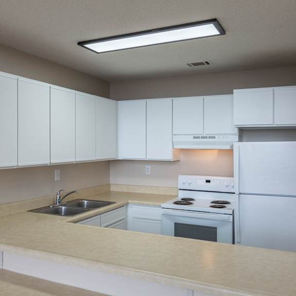 a kitchen with white cabinets and appliances.