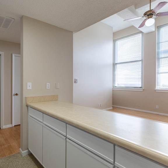 a kitchen with white cabinets and a refrigerator.