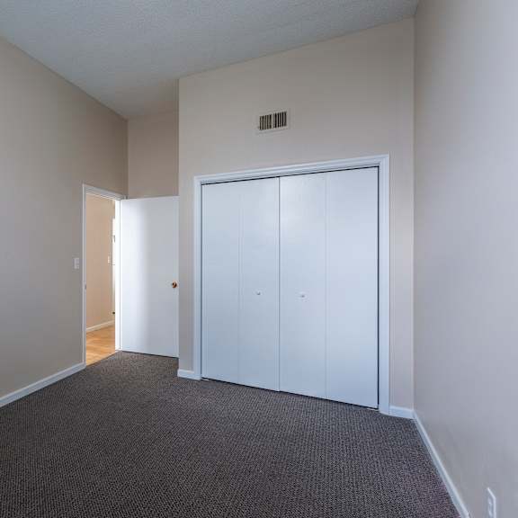 a room with a carpeted floor and a white door.