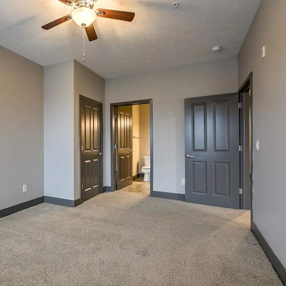 a room with a ceiling fan and carpeted floor.