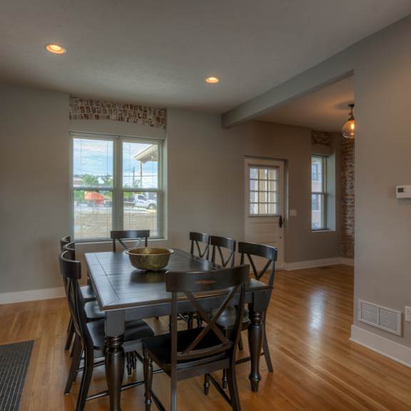 a dining room with a brick fireplace and a table set for four.