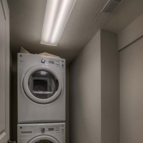 a stack of washers and dryers in a laundry room.